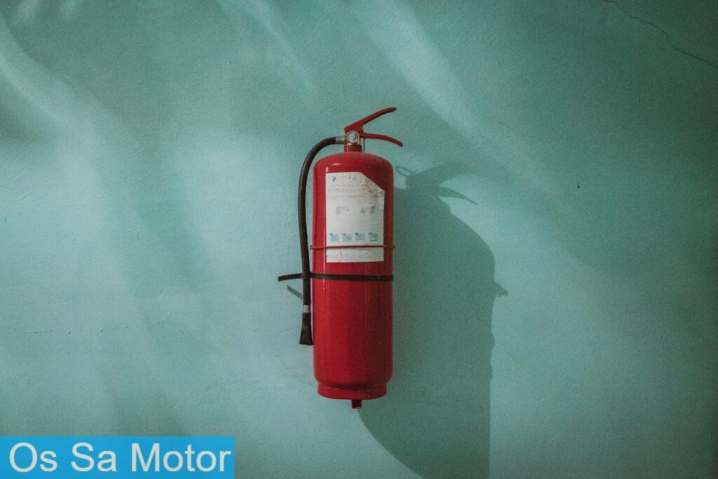 red fire extinguisher on green wall